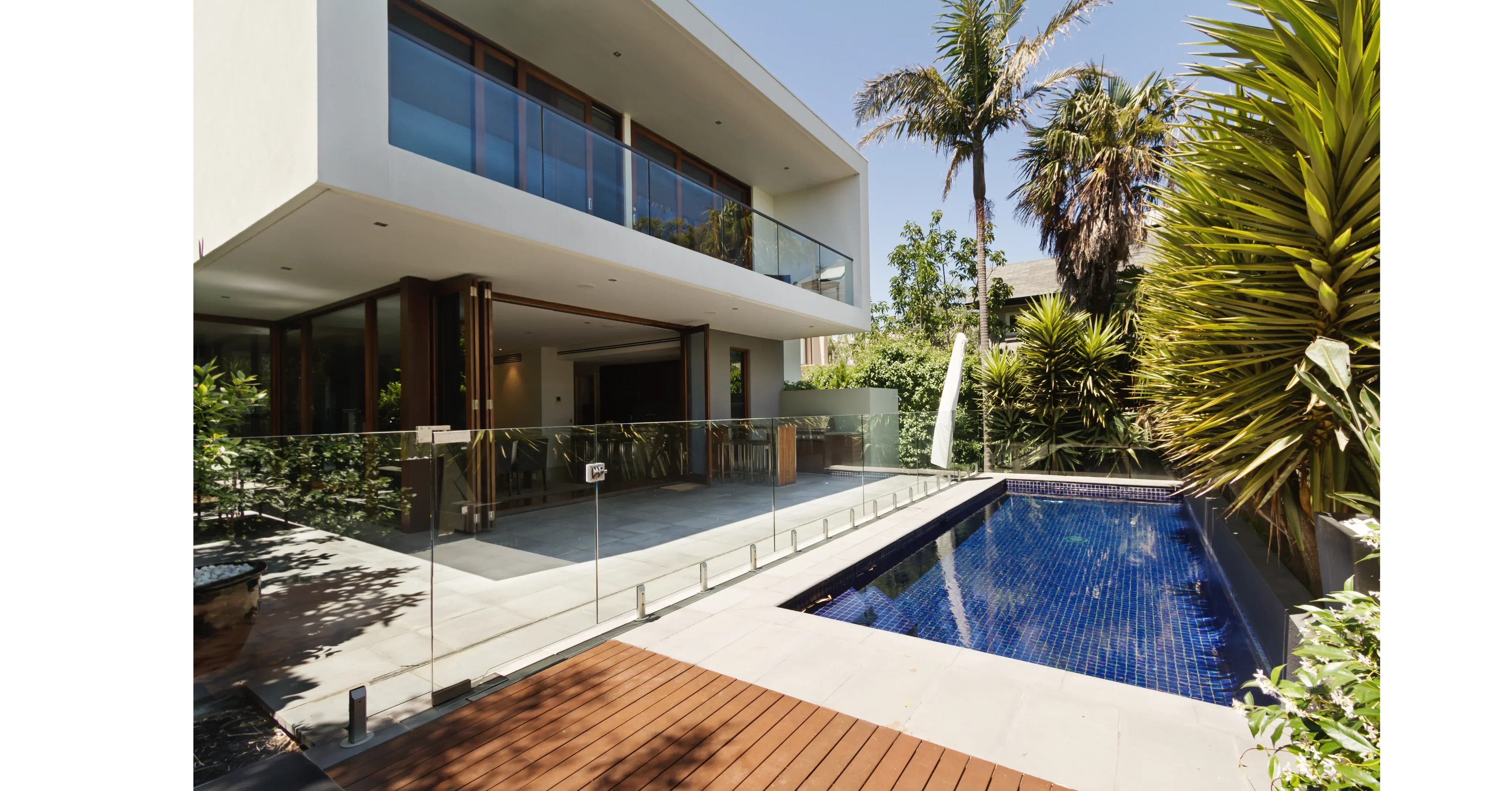 Glass pool fencing around a modern lap pool