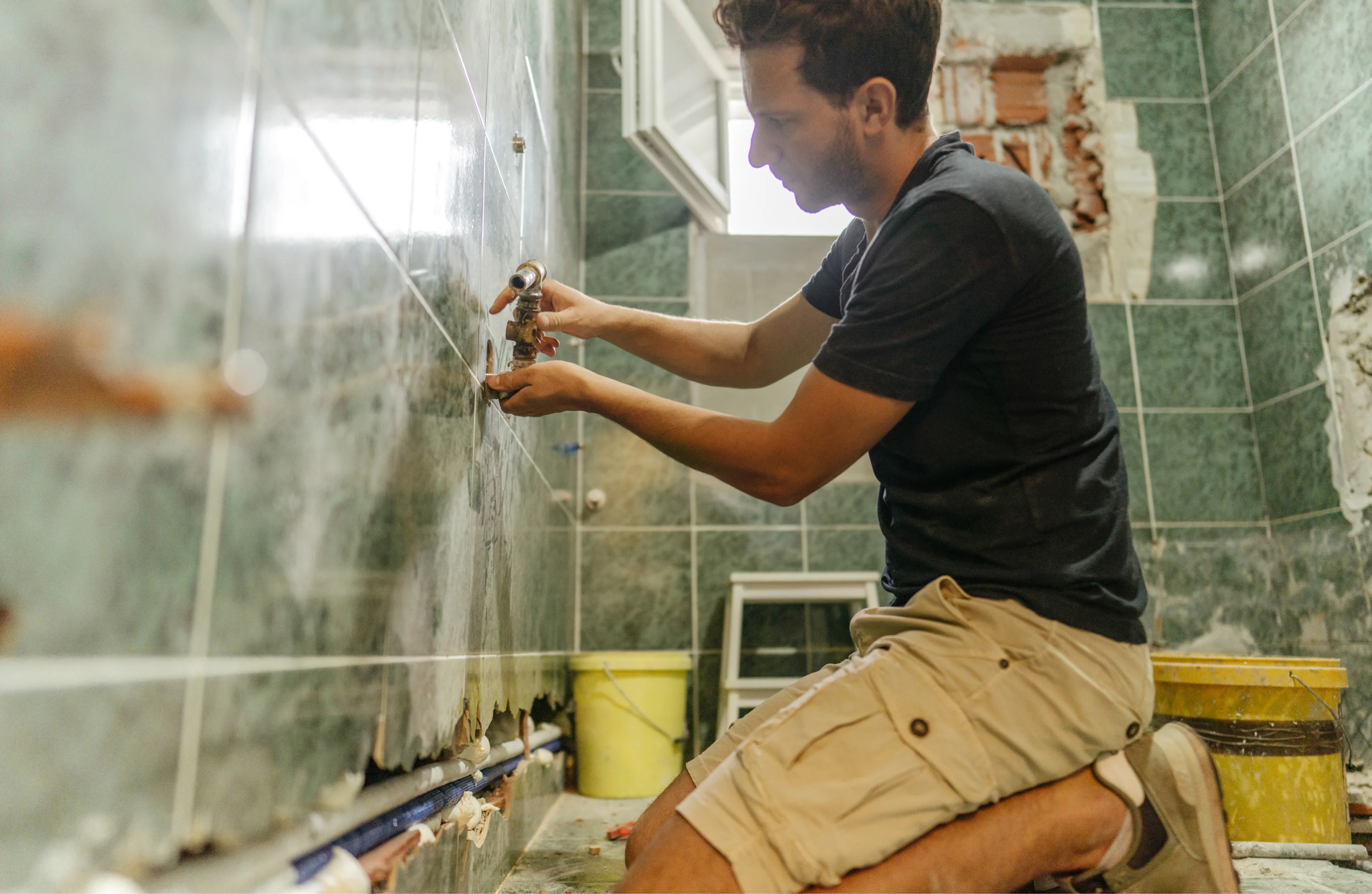 Professional bathroom renovation in Canberra showing plumbing installation, tile removal, and waterproofing work by licensed tradespeople